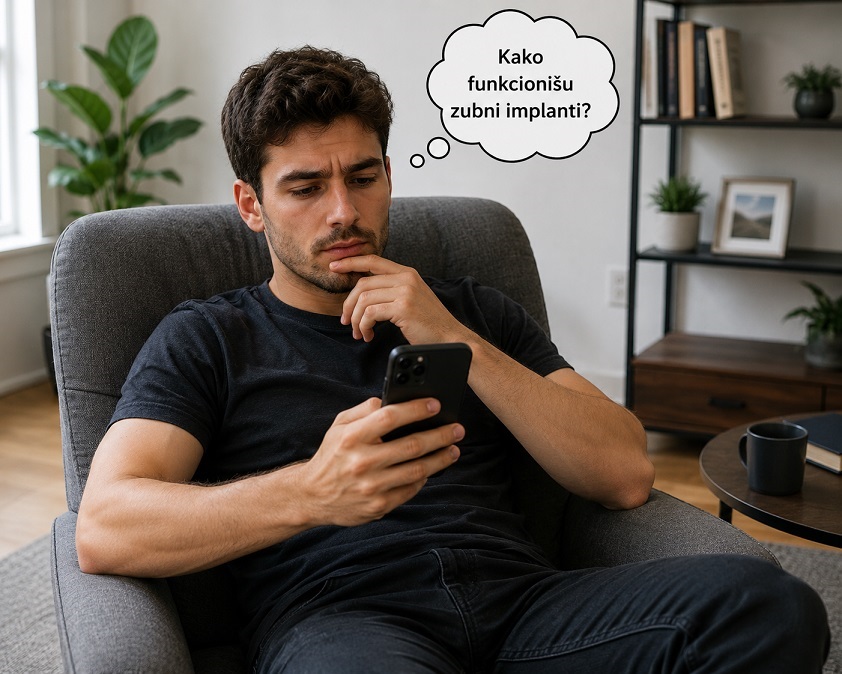 Muskarac sedi na fotelji gleda telefon i iznad glave je oblacic kako se pita kako funkcionisu zubni implanti
