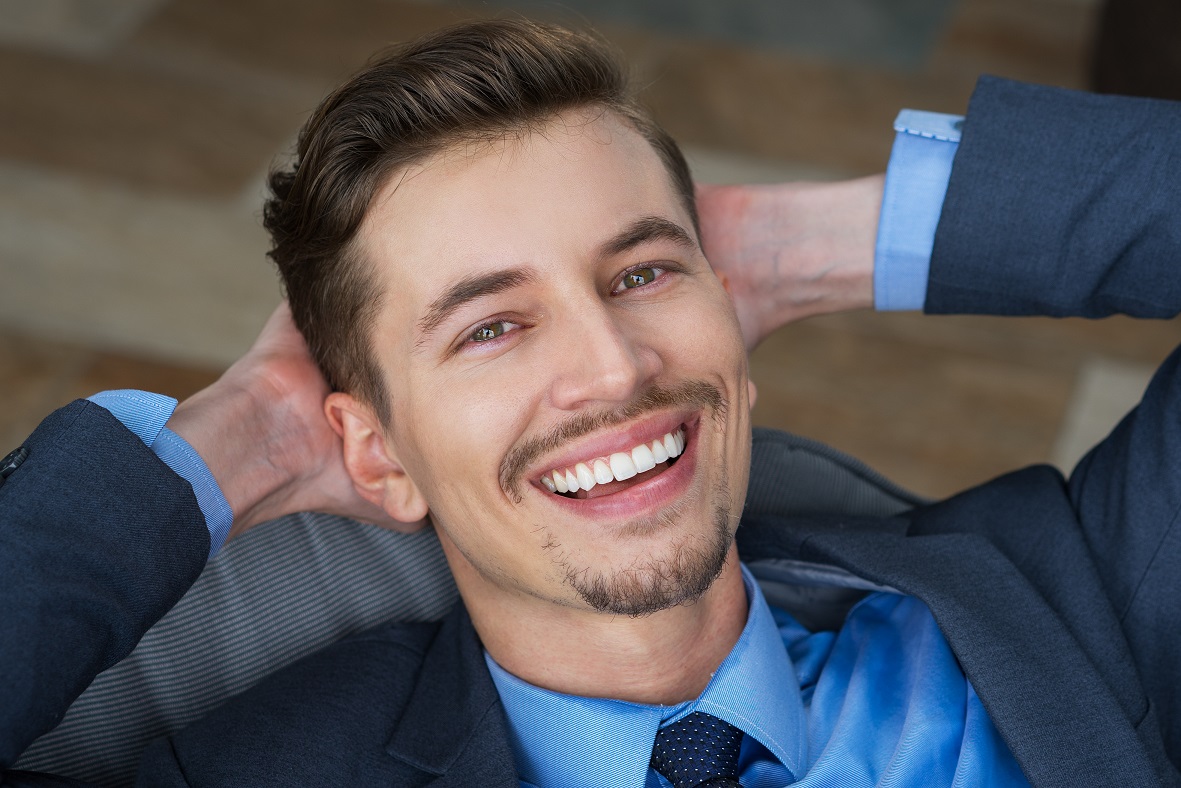 Top View of Smiling Man with Hands Behind Head